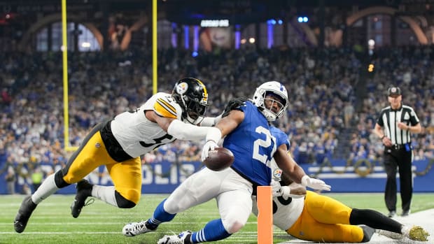 Indianapolis Colts running back Zack Moss (21) slides into the end zone for a touchdown while being chased by Pittsburgh Steelers linebacker Elandon Roberts (50) and Pittsburgh Steelers linebacker Mykal Walker (38) on Saturday, Dec. 16, 2023, during a game against the Pittsburgh Steelers at Lucas Oil Stadium in Indianapolis.